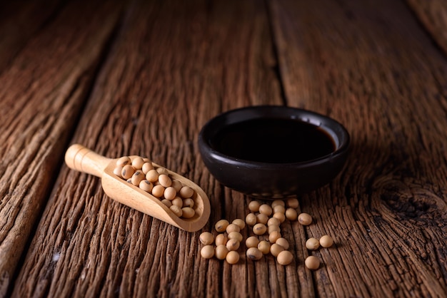 Soy Sauce with soy bean on wooden background.