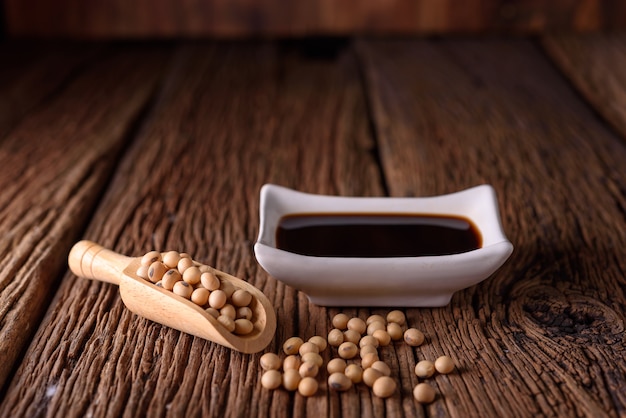 Soy Sauce with soy bean on wooden background.