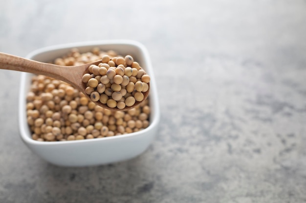 Soybean raw food nutrition in wooden spoon on a bowl