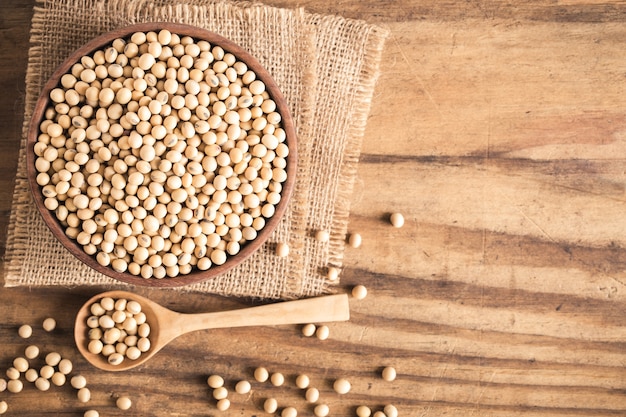 Soybeans in a wooden cup on the old wood table