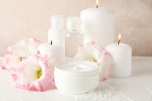 Spa accessories and beautiful flowers on white, close up