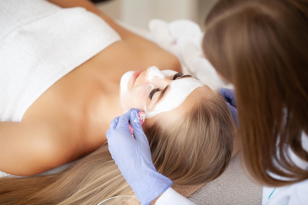 Spa, Attractive funny woman with a clay mask on her face.