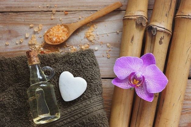 Spa background with bamboo, orchid flower, towel and stone in the shape of heart