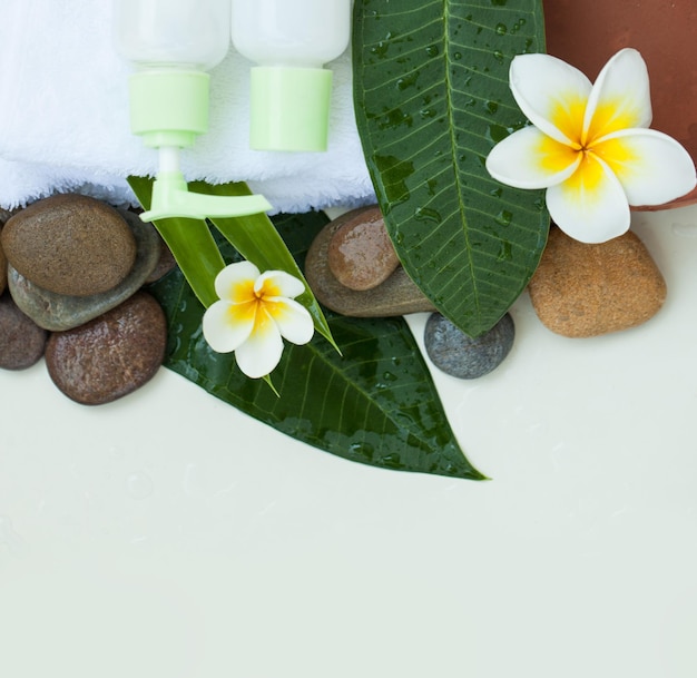 Spa background with white towels white flowers tropical leaves body and face care tools