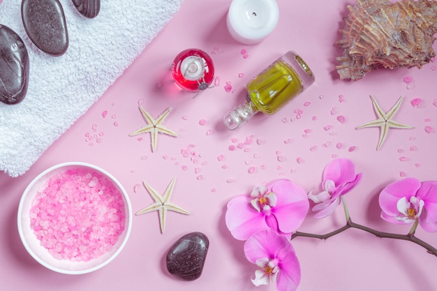 Spa beauty cosmetics on pink table from above