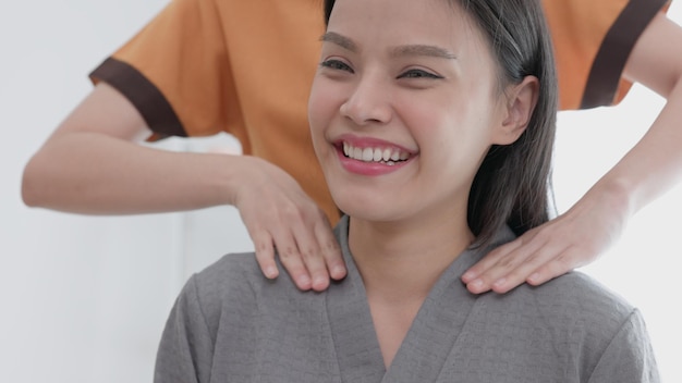 In a spa and beauty parlor a woman A female model sits and relaxes while having her neck and shoulders massaged A woman sits on a massage table relaxedxA