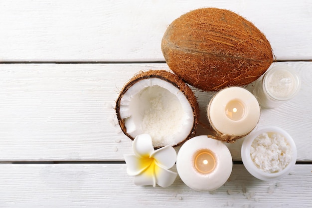 Spa coconut products on light wooden background