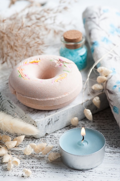 Spa composition with bath bomb donuts and dry flowers on rustic background in monochrome style. Candles and salt. Beauty treatment and relax