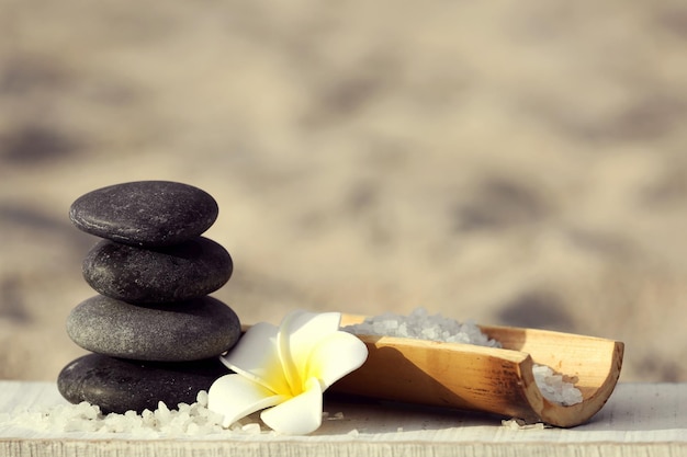 Spa composition with flower on sand beach close up