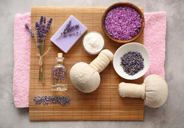 Spa composition with lavender towel and salt on gray background