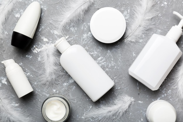 Spa cosmetic product cream jar branding mock up top view with feathers background Flat lay