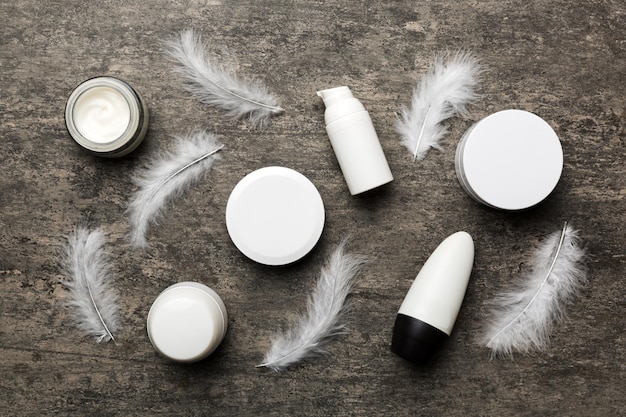 Spa cosmetic product cream jar branding mock up top view with feathers background Flat lay