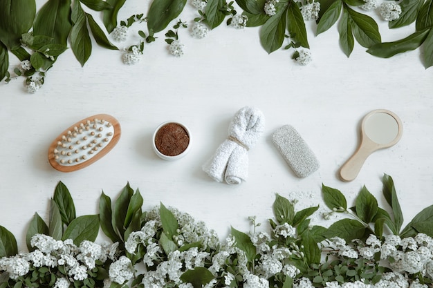 Spa flat lay composition with bath accessories, health and beauty products with fresh flowers.