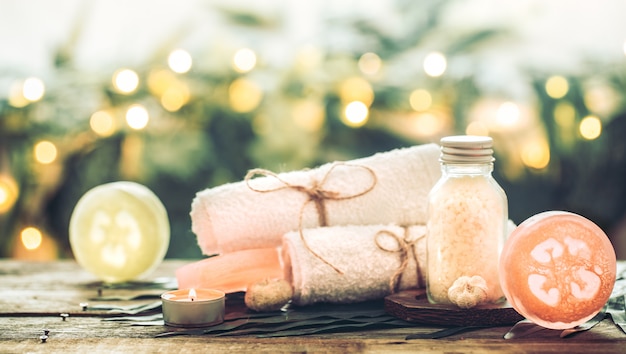 Spa handmade soap with white towels and sea salt, the composition of the tropical leaves with a candle, wooden table