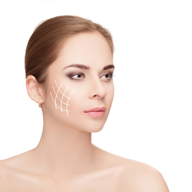 Spa portrait of attractive woman with arrows on her face over white background. Face lifting concept. Plastic surgery treatment, medicine