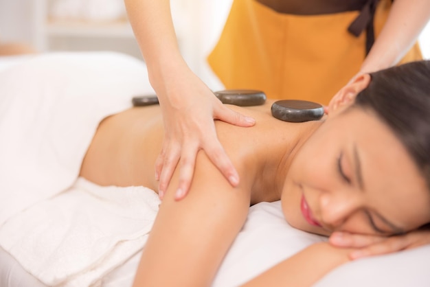 In a spa salon a young woman enjoys massage therapy