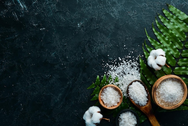 Spa Sea salt in a bowl On a black stone background Top view Free space for your text