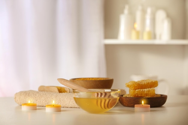 Spa set with honey treatments and candles on white table