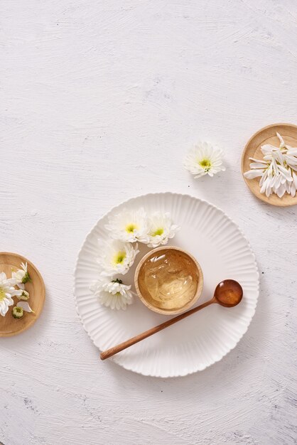 Spa setting with cosmetic gel, leaves on white table background