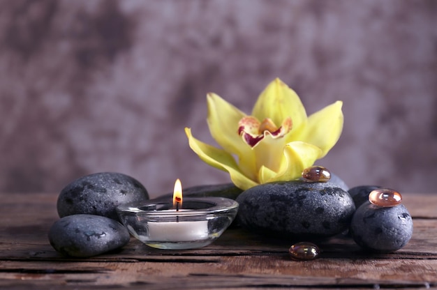 Spa still life with stones flower and candlelight on blurred pastel background