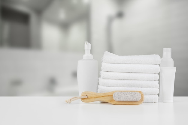 Spa still life with towels and skincare cosmetics against blurred background