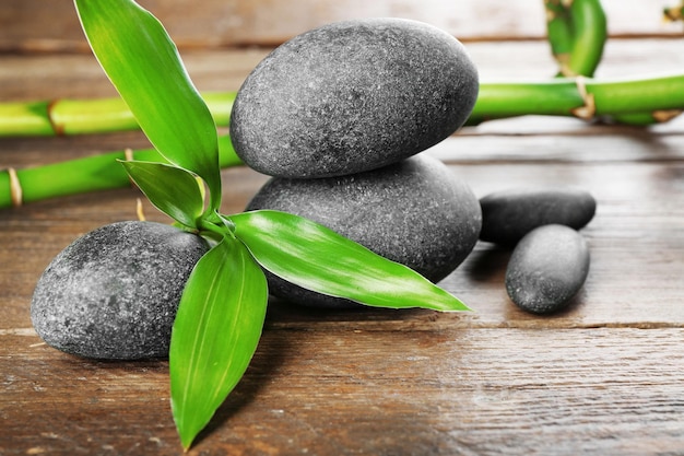 Spa stones and bamboo branch on wooden background