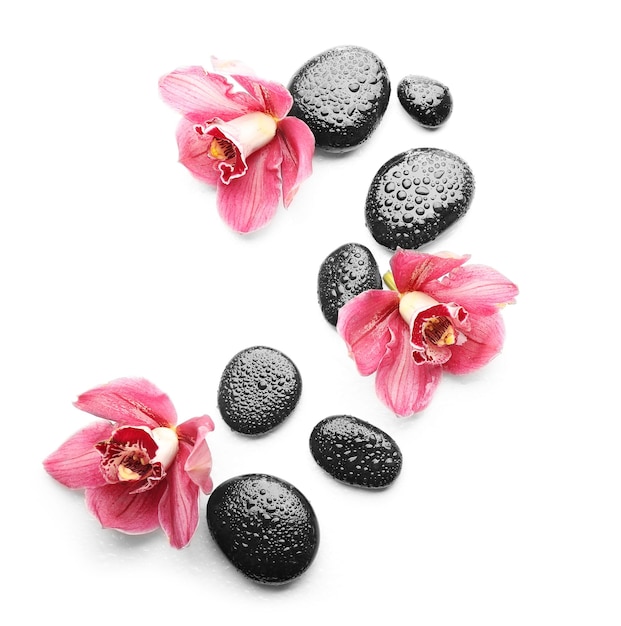 Spa stones and beautiful pink orchids on white background