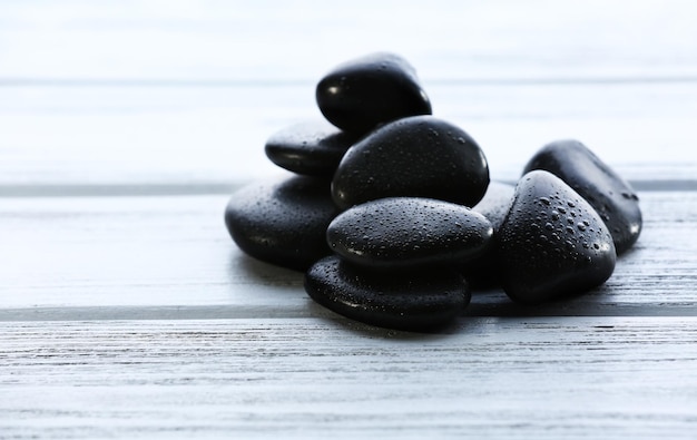 Spa stones with water drops on wooden background