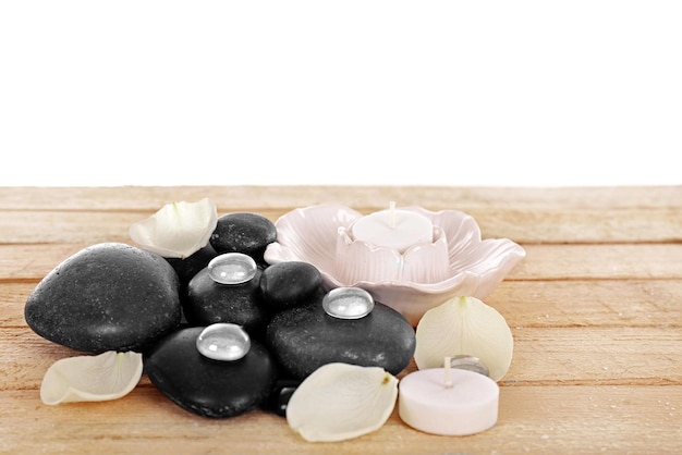 Photo spa stones with white petals and candles on white background