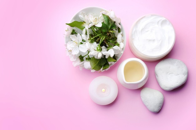 Spa treatment with blooming branch on pink background