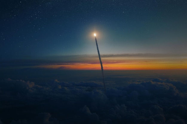 Space rocket shuttle with blast and smoke flies through clouds into starry space at sunset Spacecraft successfully takes off from the planet Earth into outer space Rocket launch concept