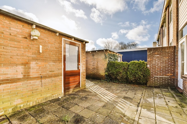 A spacious backyard with tiled floors and a small warehouse near a cozy apartment building