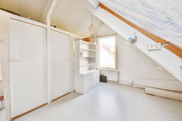 A spacious empty room on the top floor of a modern house with a sloping ceiling in white