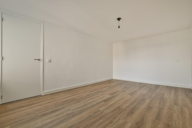 Spacious empty room in white with parquet floor in a modern house