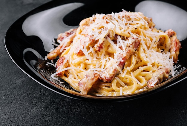 Spagetti carbonara on a black plate