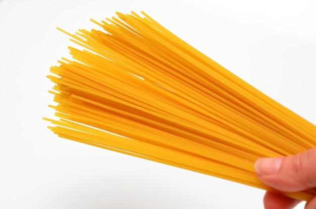 Spaghetti in hand closeup on a white background