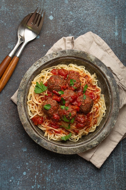 Photo spaghetti and meatballs with tomato sauce served on rustic