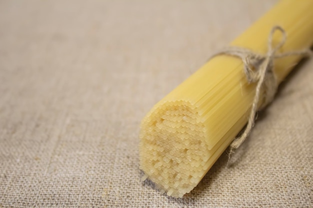 Spaghetti pasta tied with string on a linen tablecloth The concept of cooking cuisine catering