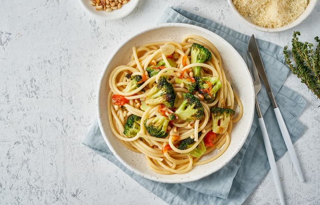 Spaghetti pasta with broccoli, bucatini with peppers, garlic, pine nuts. Food for vegans, vegetarians