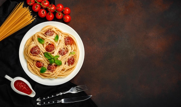 Spaghetti pasta with meatballs cherry and tomatos sauce on rusty background