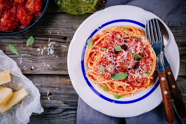 Spaghetti pasta with meatballs tomato sauce and parmesan cheese on wooden background