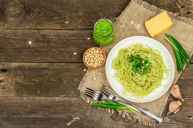 Spaghetti pasta with pesto sauce and fresh ramson leaves Cutlery parmesan pine nuts Rustic style