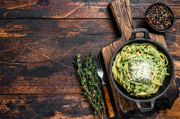 Spaghetti Pasta with pesto sauce, spinach and parmesan in a pan