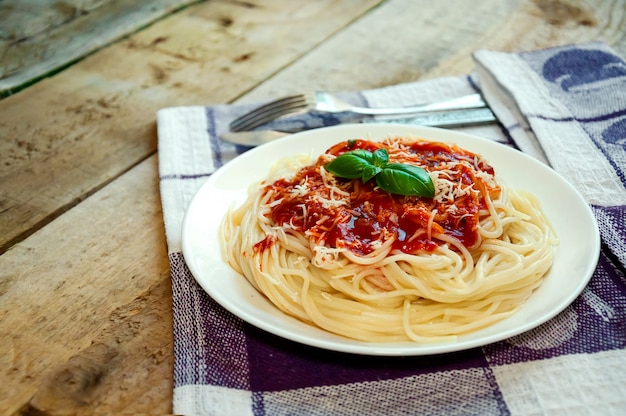 Spaghetti Pasta with Tomato Sauce, Cheese and Basil on Wooden Table. Traditional Italian Food