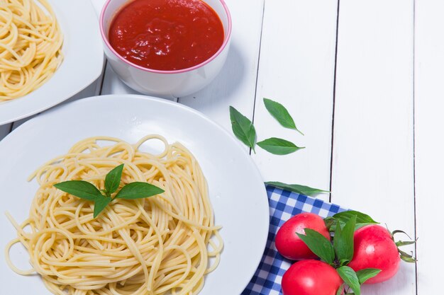 Spaghetti pasta with and tomato sauce on wood background