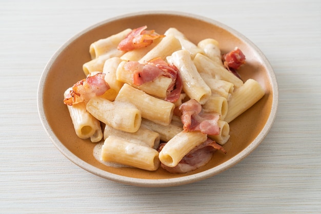 Spaghetti rigatoni pasta with white sauce and bacon