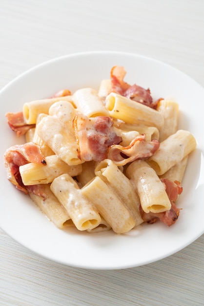 Spaghetti rigatoni pasta with white sauce and bacon