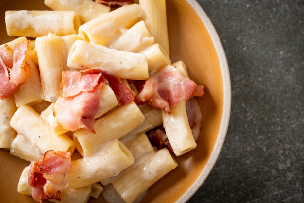 Spaghetti rigatoni pasta with white sauce and bacon