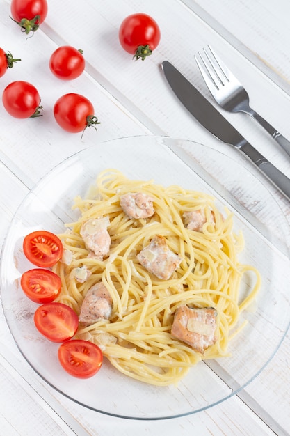 Spaghetti with fish on a transparent glass plate