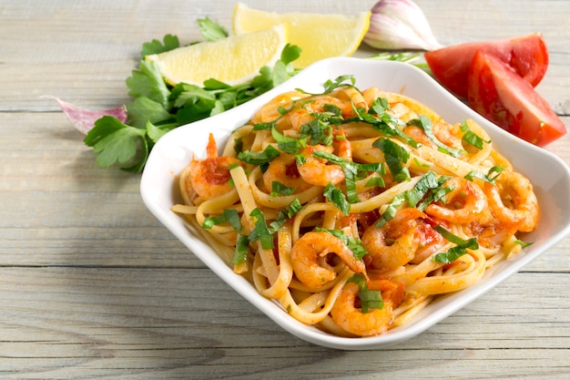 Spaghetti with prawns in tomato sauce with herbs.